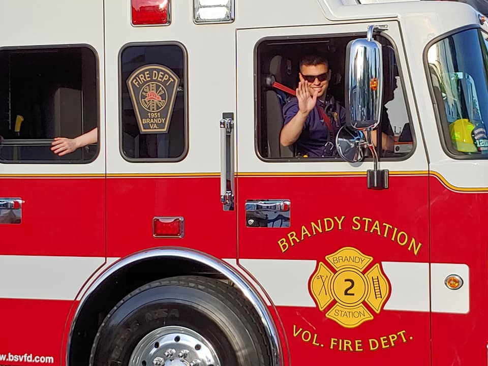 A man in the driver 's seat of a fire truck.